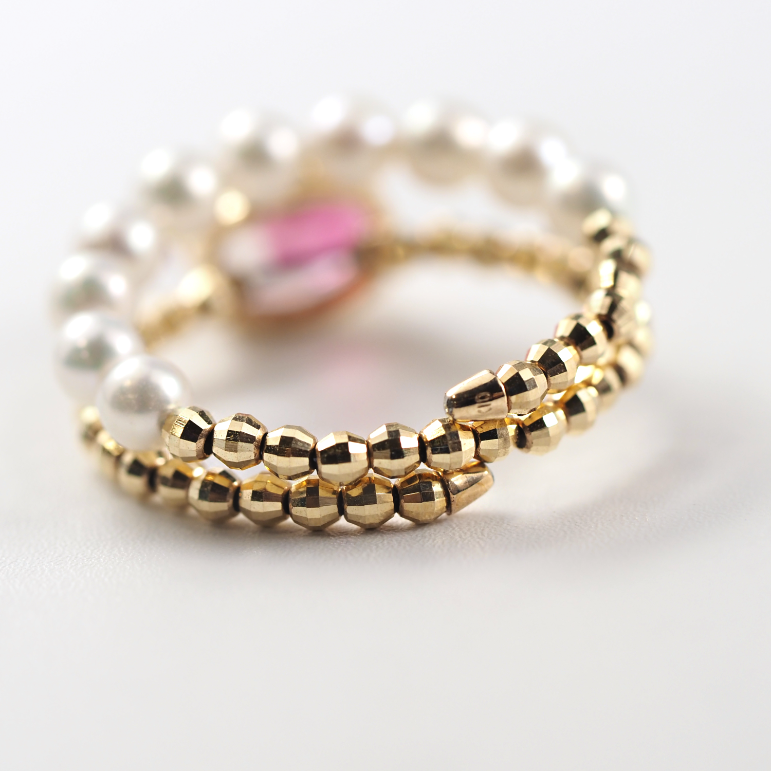 光の角度によって淡く輝きを返すピンクトルマリンが、洗練された指先を演出するMITUREのジュエリーの裏側画像。