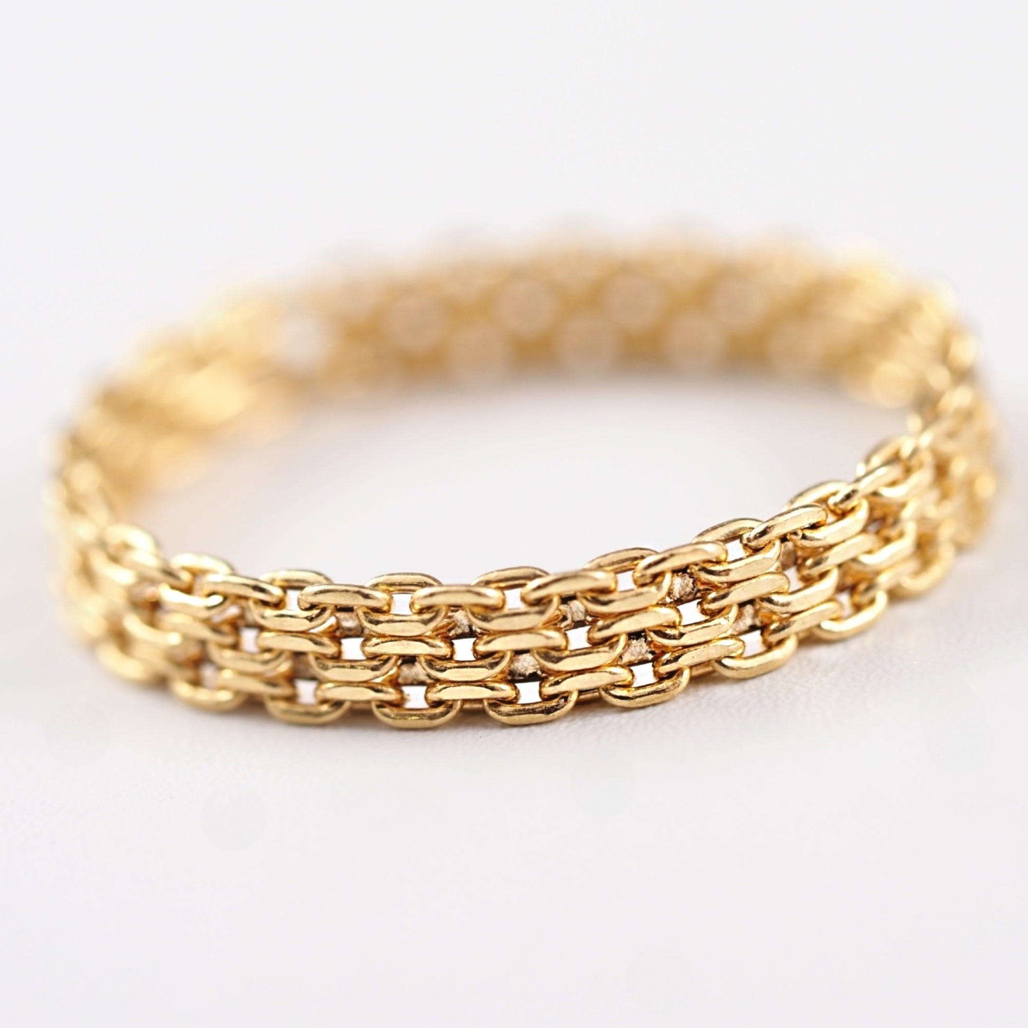 平打ちリングのようなフォルムを持たせたデザインが印象的な、MITUREのK18チェーンリング。地金の艶が立体的に輝きます。