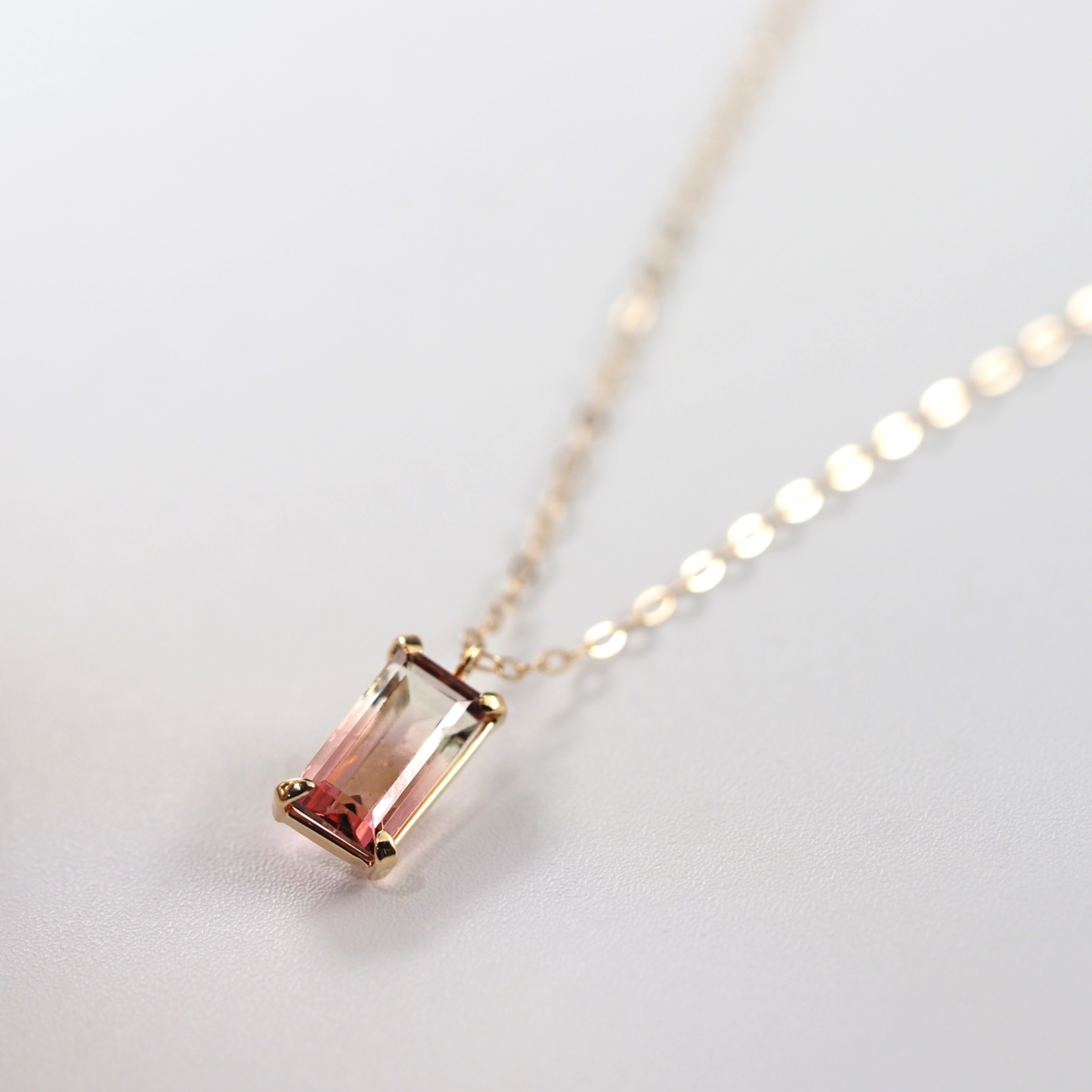 4本爪でシンプルに留めたスクエアデザインが、色の移ろいをすっきりと引き立てるMITUREのネックレス。