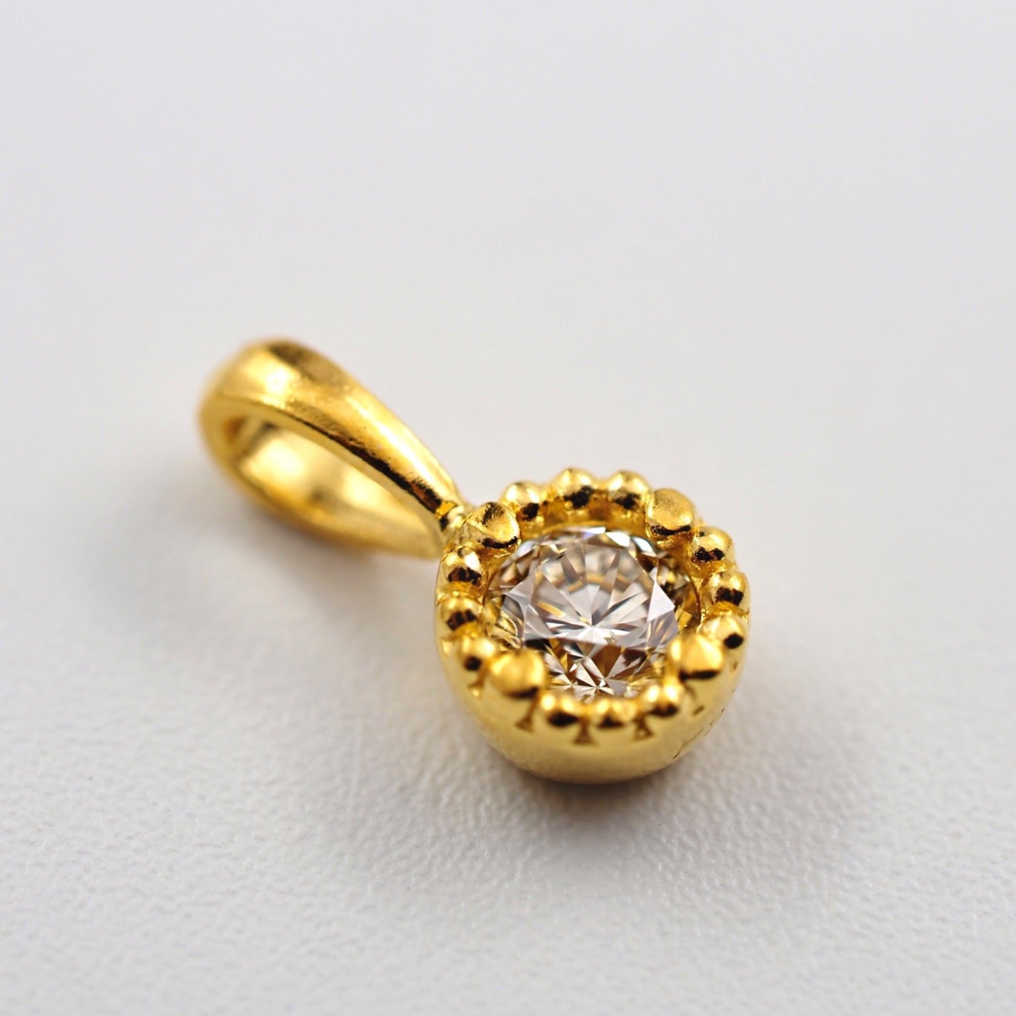 純金ならではのやわらかく深みのある黄金色に、0.1ctのダイヤモンドを一粒あしらったMITURE（ミチュール）のK24ペンダントトップ。