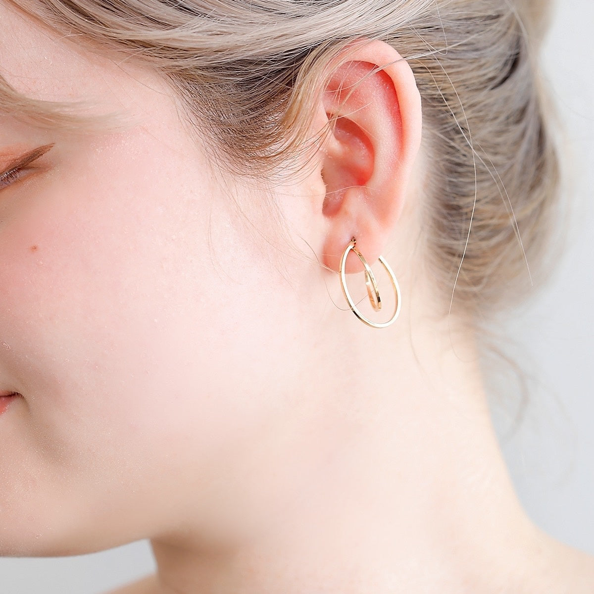 シンプルな装いにもモダンなアクセントを添える、山梨県甲府市で製作したMITUREのボリュームサークルピアス。