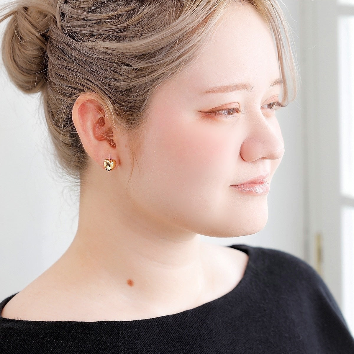 左右で異なるデザインがさりげない個性を引き立てる、MITUREのハートモチーフピアス。やわらかなゴールドの輝きが印象的。