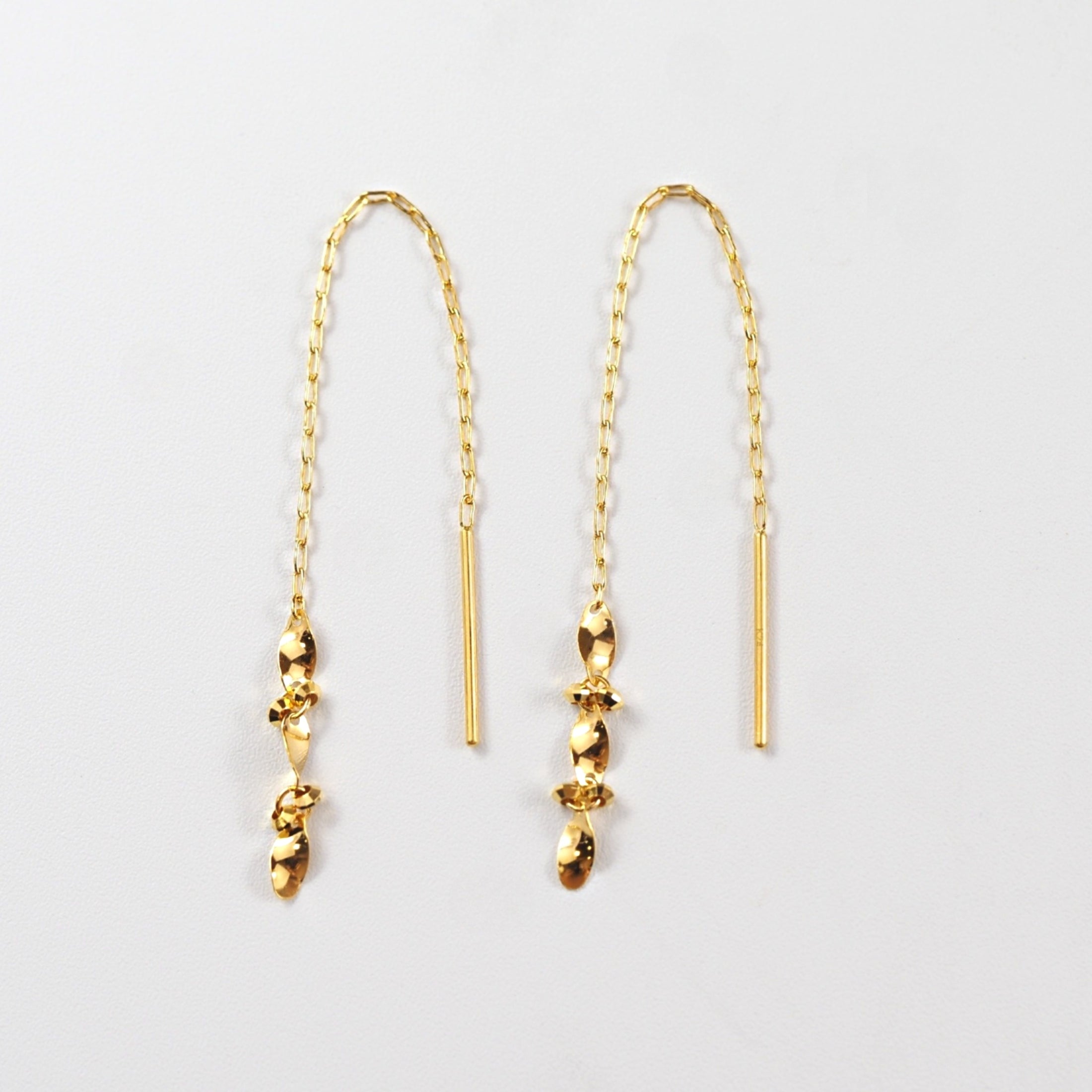 葉のようにひねりを加えたパーツと小豆チェーンが連なる、MITURE（ミチュール）の純金チェーンピアス。軽やかな動きが印象的。