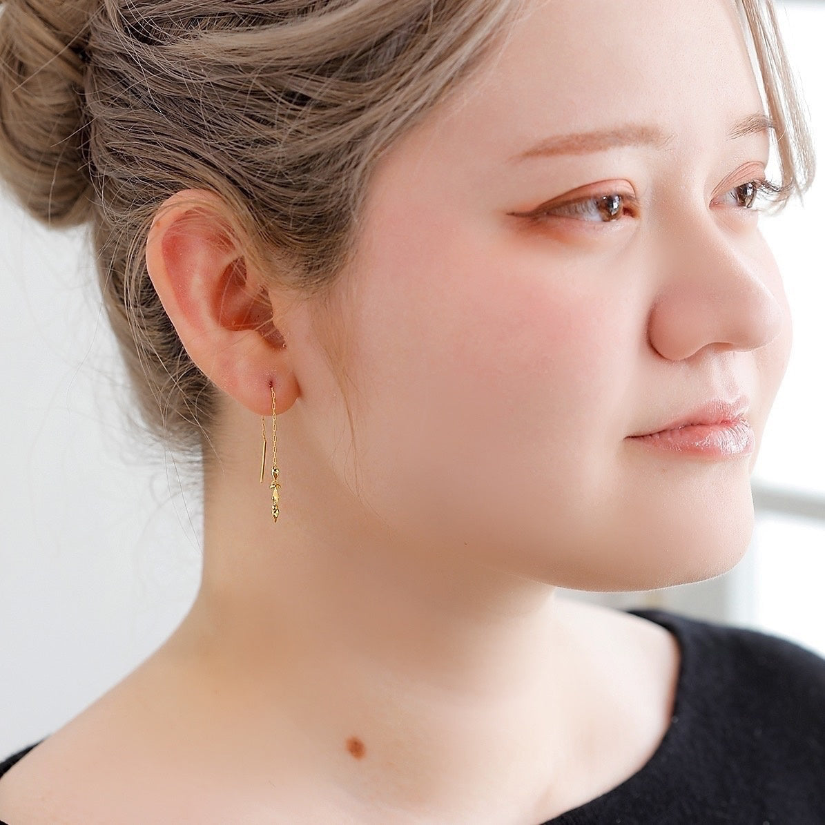 縦に落ちるラインが顔まわりをすっきりと引き立てる、MITUREの純金ピアス。動きに合わせて繊細な輝きを楽しめます。