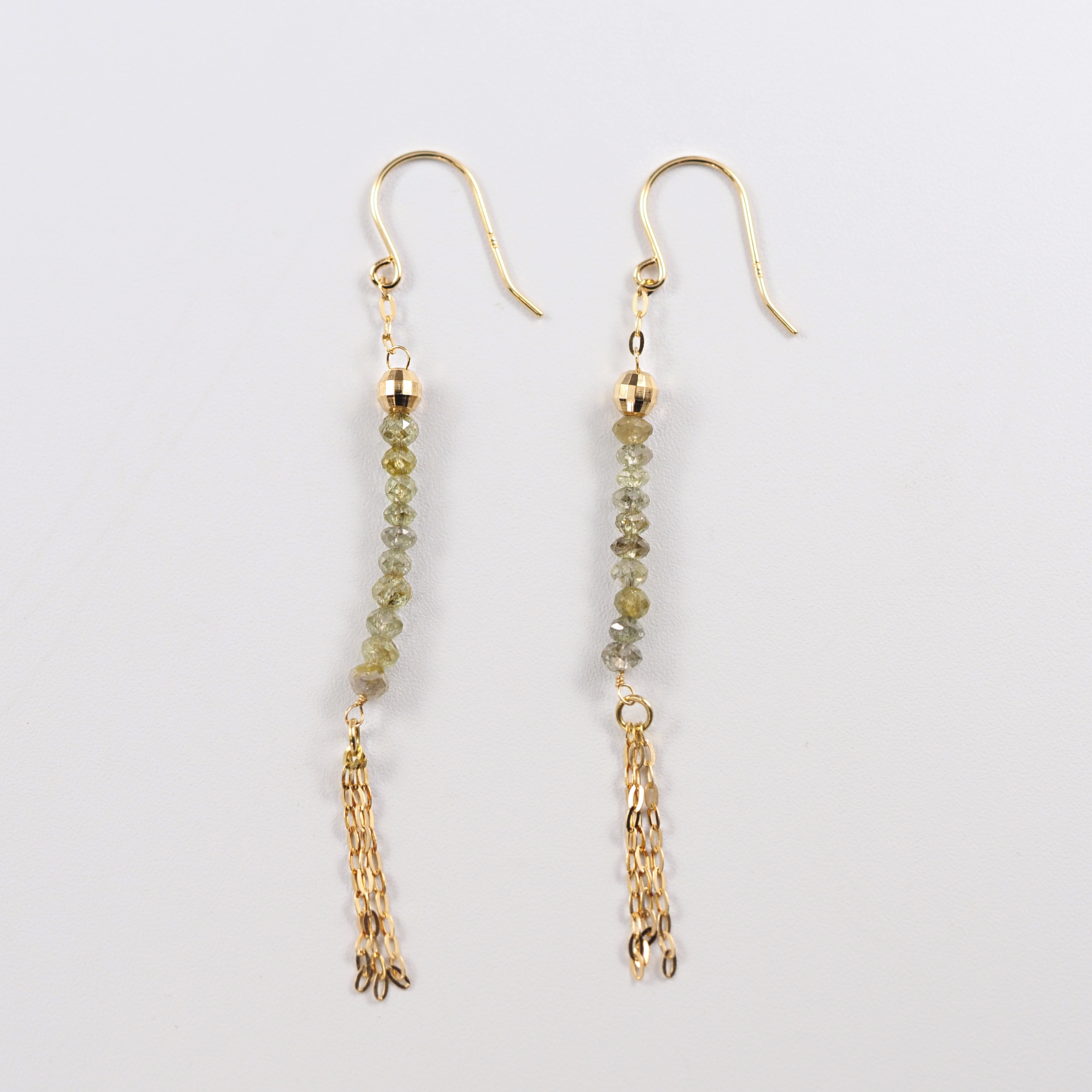 グリーンカラーのダイヤモンドを連ねたタッセルデザインが、落ち着いた華やぎを添えるMITURE（ミチュール）のフックピアス。K18素材で上品な輝き。