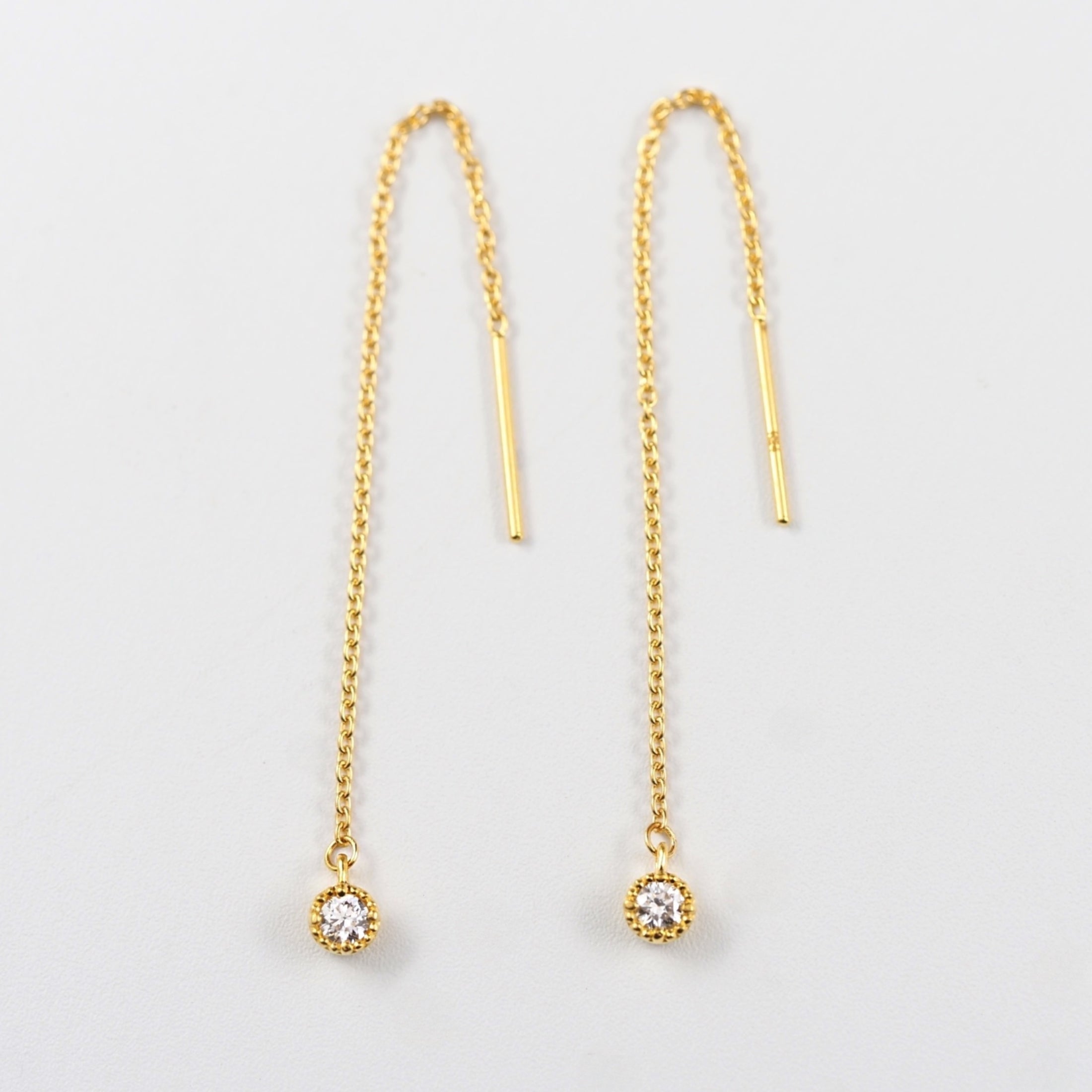 ミル打ち枠に留めた一粒ダイヤモンドと小豆チェーンを組み合わせた、MITURE（ミチュール）の純金チェーンピアス。やわらかなゴールドの色味が印象的。