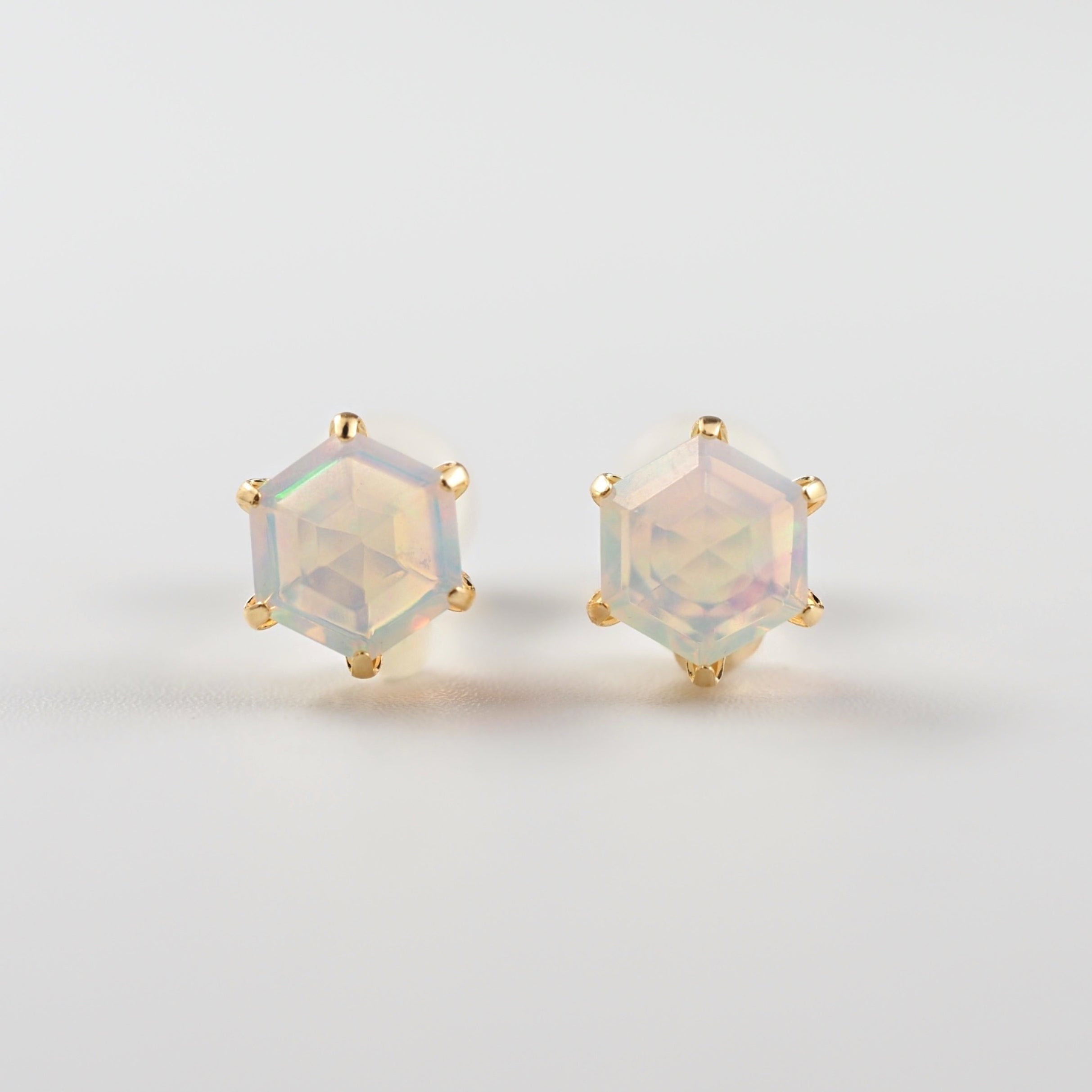 やわらかな乳白色の中に、角度によって虹色の光を浮かべるオパールが印象的なMITUREのヘキサゴンピアス。