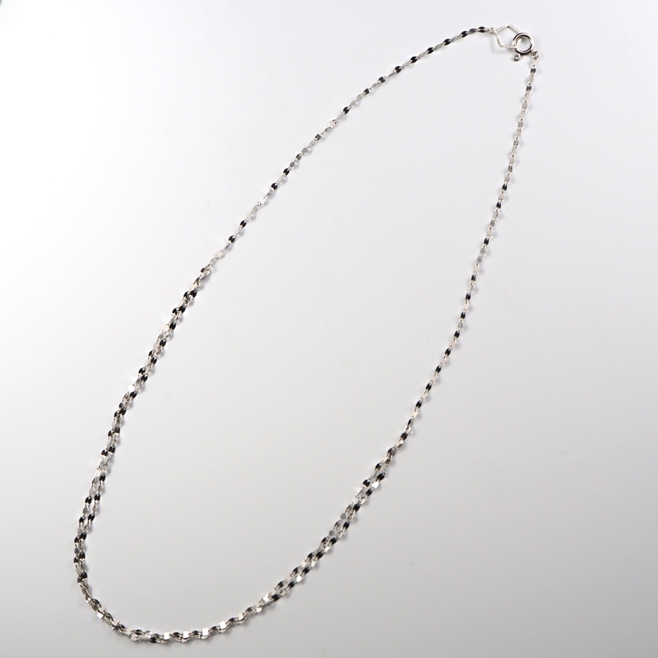 立体的に連なるチェーンが光を受けて繊細に揺れる、MITUREの純プラチナ2連デザイン。