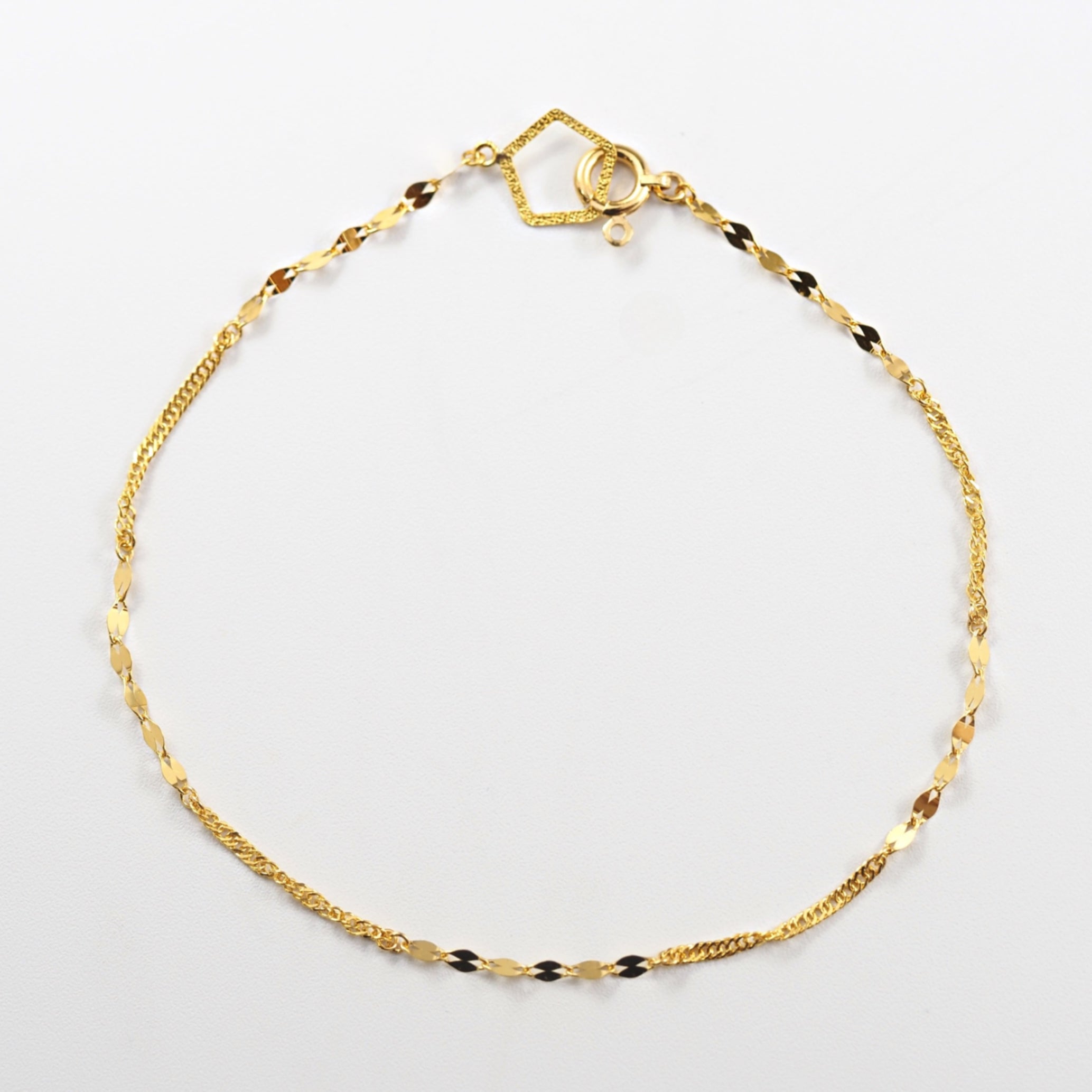 K24の深い輝きを生かした、MITURE（ミチュール）の17cm純金ブレスレット。ペタルチェーンとスクリューチェーンの組み合わせが上品に映えます。