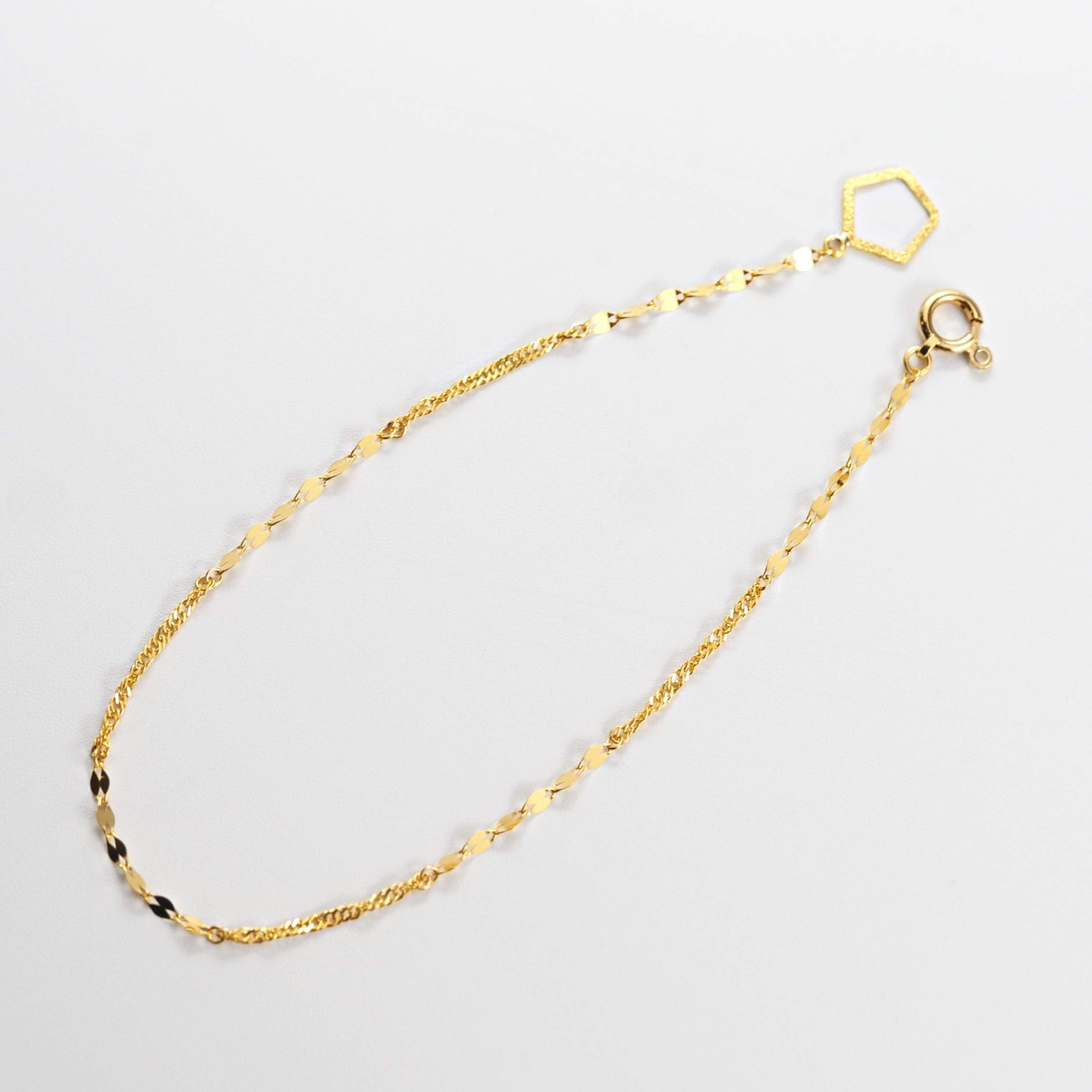 光を受けて細やかに揺れるチェーンが、角度ごとに豊かな表情を見せるMITUREの純金デザインブレスレット。