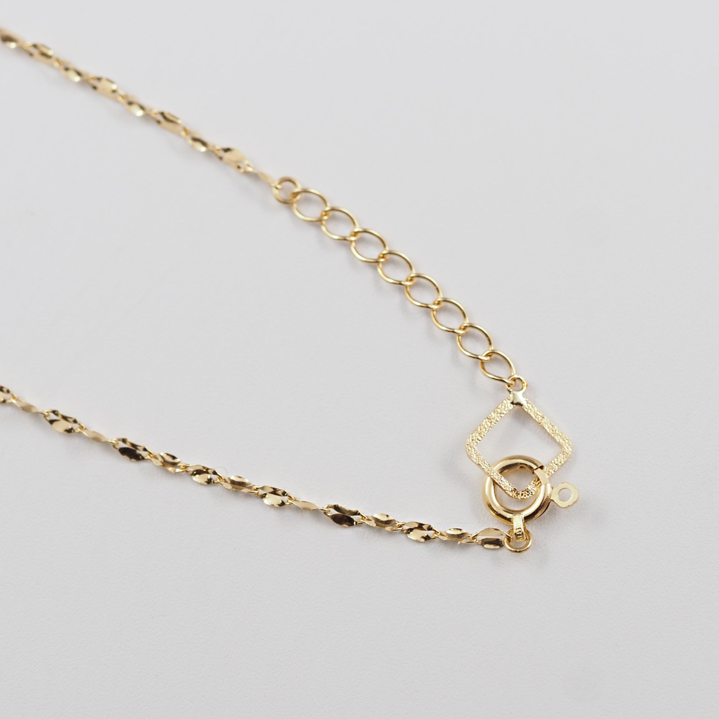 連なるチェーンパーツが光を受けて美しく映える、MITUREのK18ゴールドブレスレット。一本でも手元に存在感を添えます。