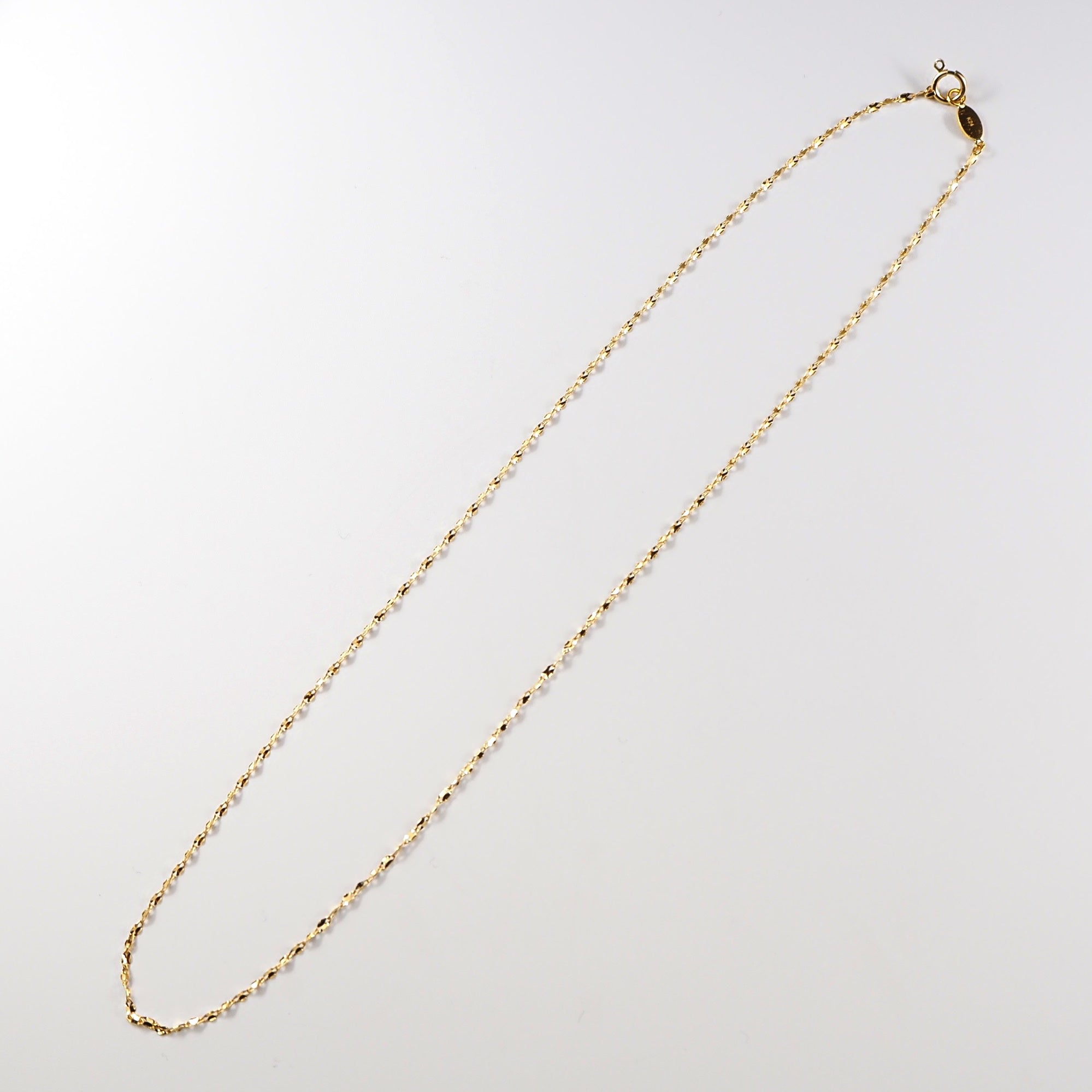 やさしく光を反射する純金の質感が、首元に落ち着いた奥行きをもたらすMITUREのゴールドネックレス。