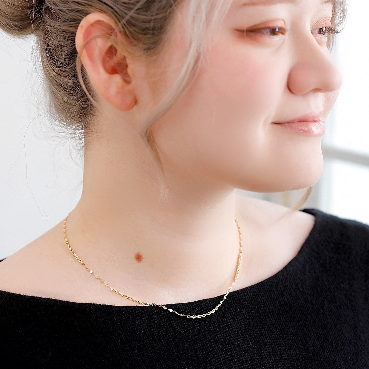 異なるチェーンの輝きが首元で繊細にきらめく、MITURE（ミチュール）のK18デザインネックレス着用イメージ。上品で華やかな印象。