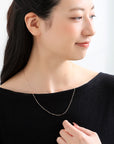 K18ゴールドのクリップチェーンネックレスを着用したモデル。幅感のあるチェーンが胸元で上品に輝く、山梨県甲府市で製作したMITUREの18金ネックレス。