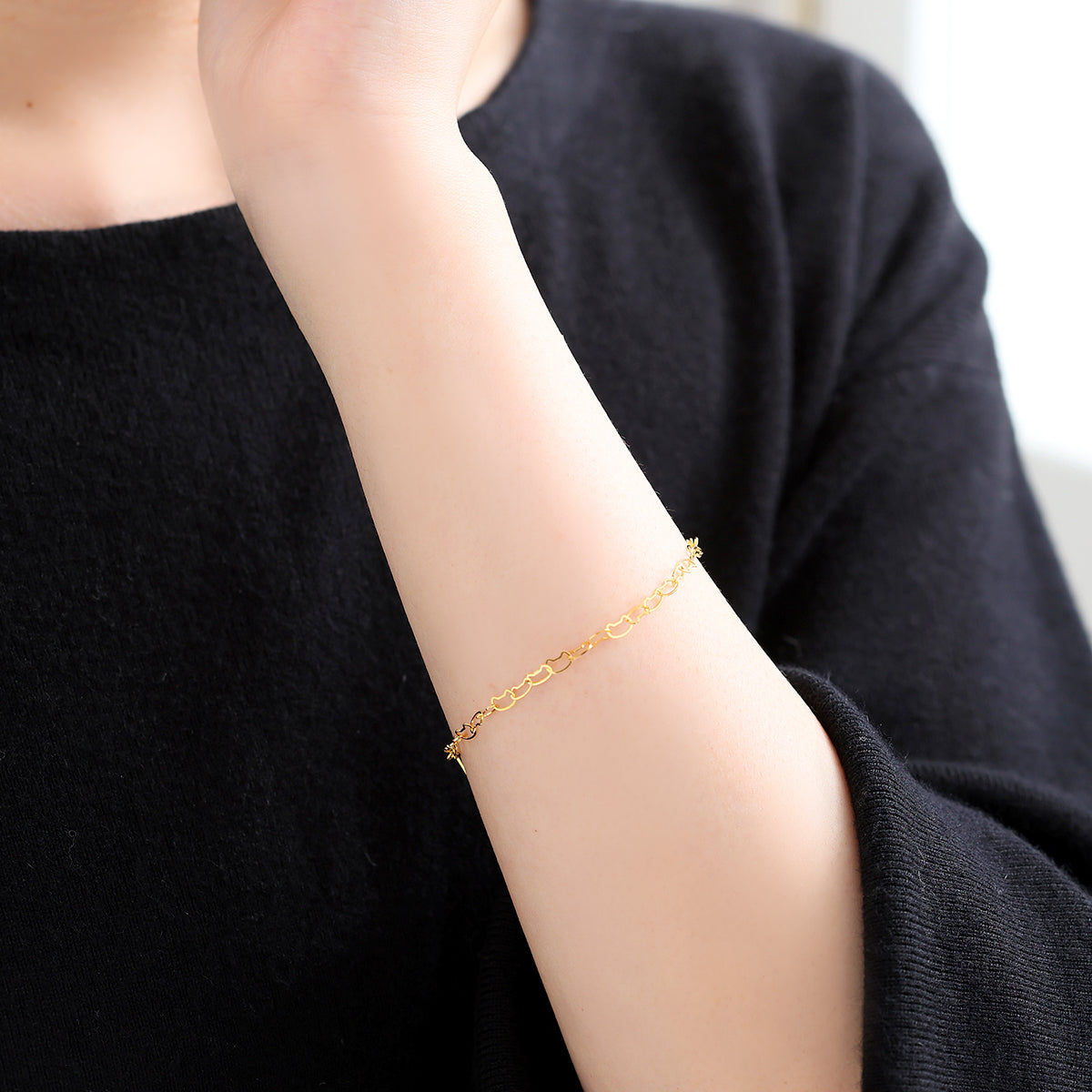 小さなネコモチーフが手元を愛らしく彩る、MITUREのK24純金ブレスレット着用イメージ。深みのある黄金色が、大人の装いに上品な華やかさと遊び心を添えます。