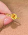 指の動きに合わせて、ひし形の枠の中でオレンジサファイアがぷるぷると揺れるMITUREのK18リング。揺れるたびに光を受け、鮮やかなオレンジの表情が変化します。